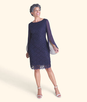 Woman posing wearing Navy Stevie Navy Sequin Lace Dress from Connected Apparel