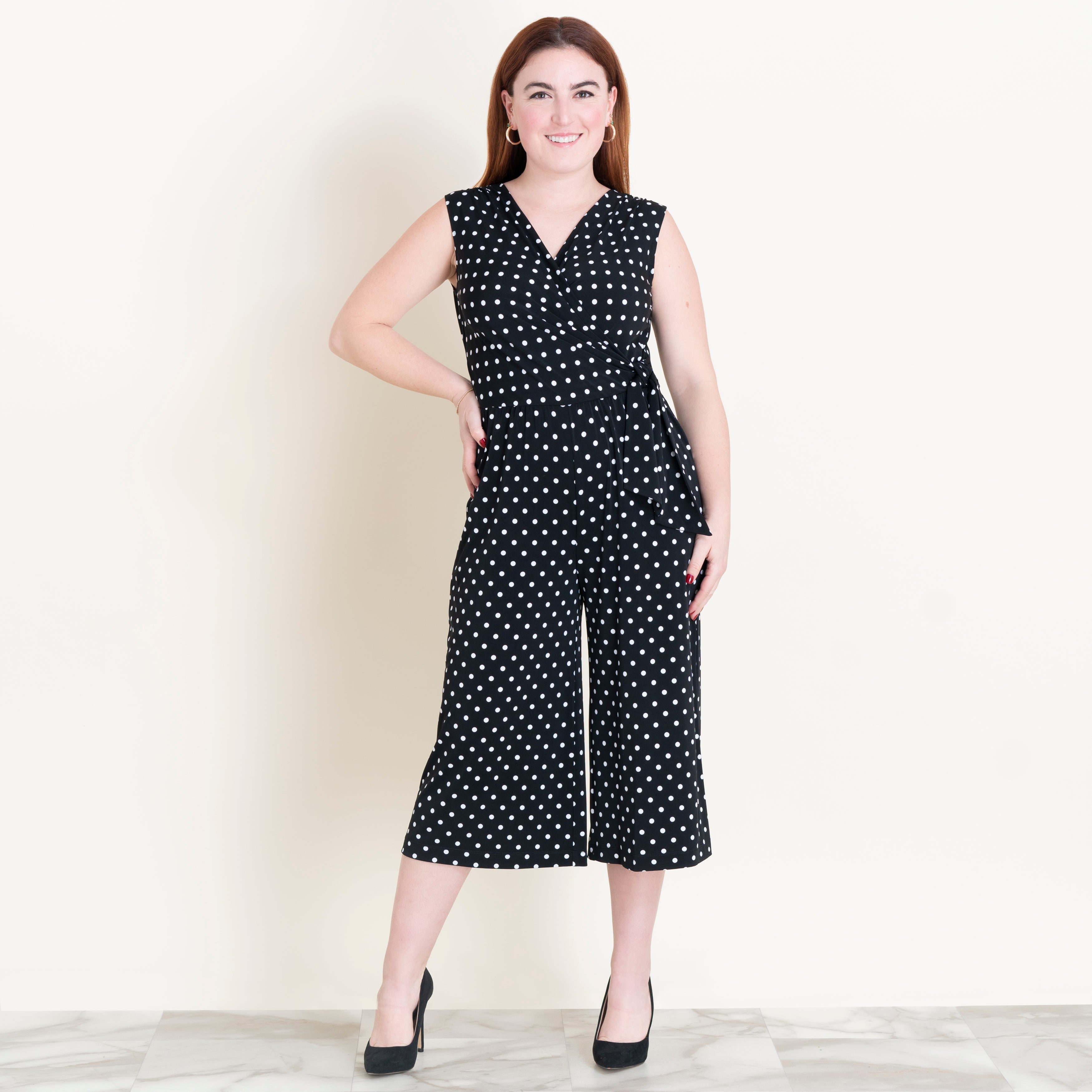 Woman posing wearing Black Morgan Black and White Polka Dot Jumpsuit from Connected Apparel